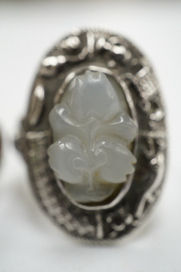 Two Chinese or Burmese jadeite or jade mounted white metal rings. Condition - fair